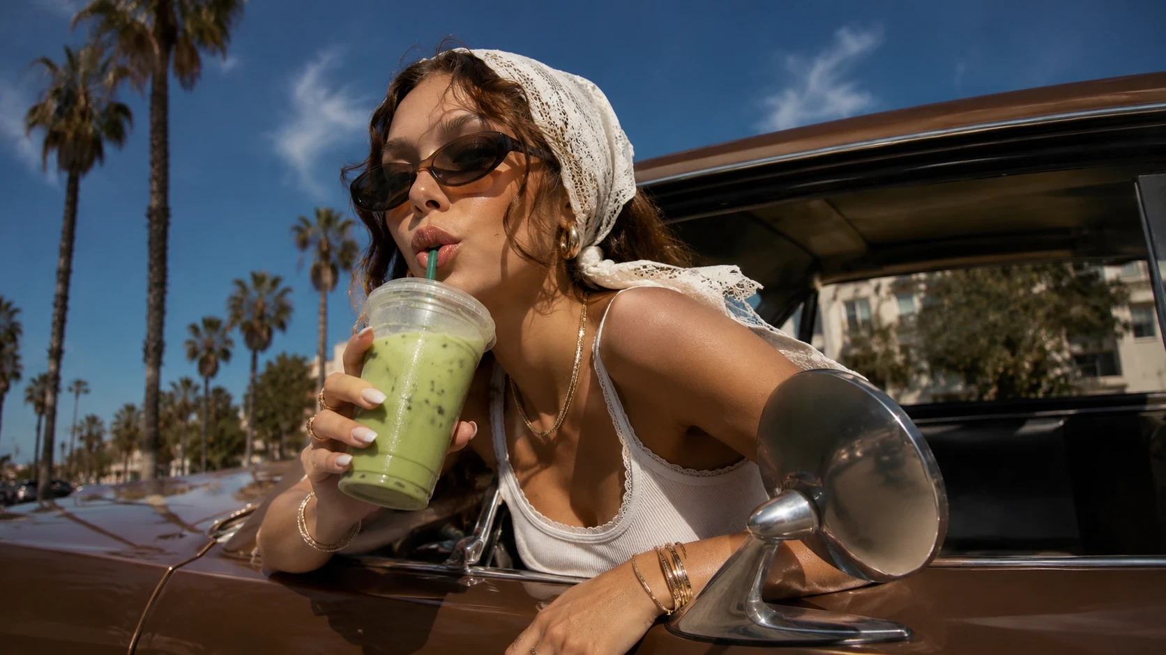 Vrouw met zonnebril drinkt matcha naast een auto